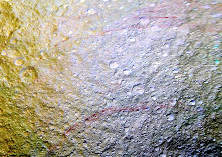 Renklendirilmiş görüntülerde Tetis yüzeyindeki kavisli kırmızı çizgiler (NASA/JPL-Caltech/Space Science Institute)