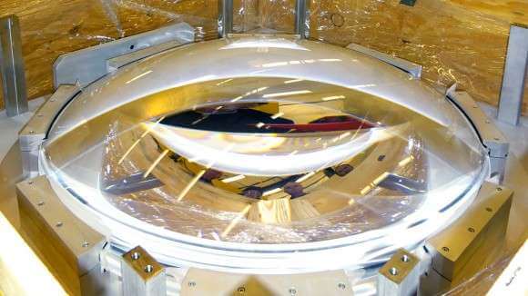 The C4 lens after it arrived at the NOAO. The faces of Gary Poczulp, Ron Probst, Dick Joyce and Ming Liang (project scientists for DESI) are reflected in the lens. Credit: Tim Miller/LBL Read more at: http://phys.org/news/2016-03-lenses-dark-energy.html#jCp